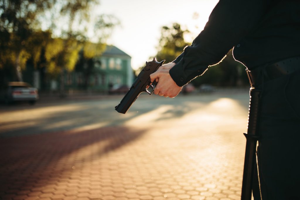 Male cop in uniform with gun in hands